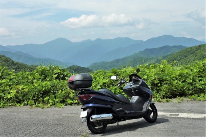 ツーリング中に景色の良い場所で休憩しているイメージ